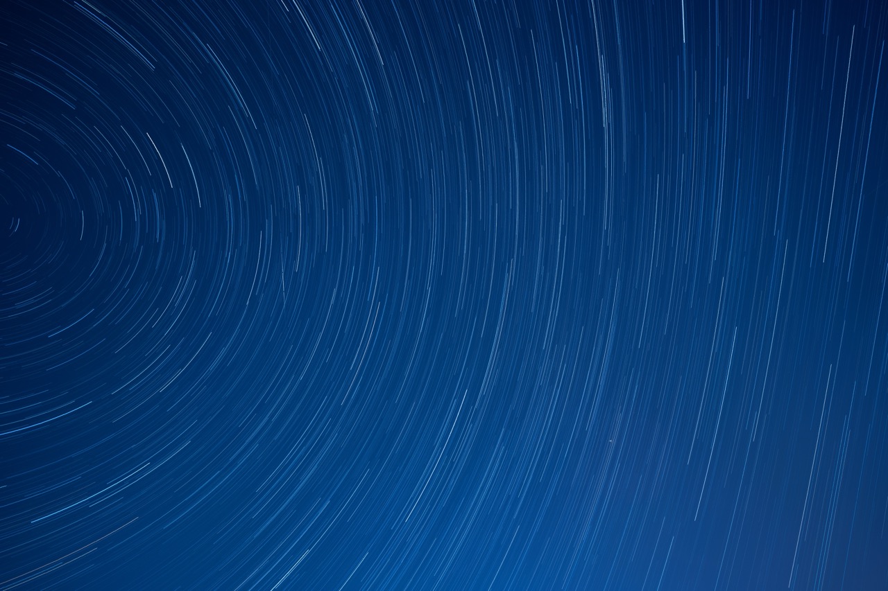 Star trails above tiled roofs of a Beijing courtyard.