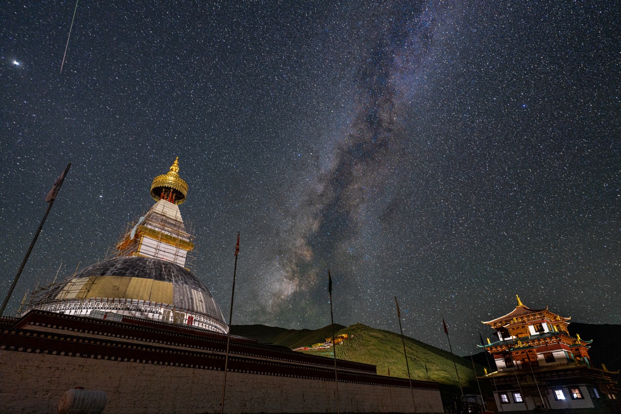 Buddha statue glowing beneath the Milky Way in Qinghai.