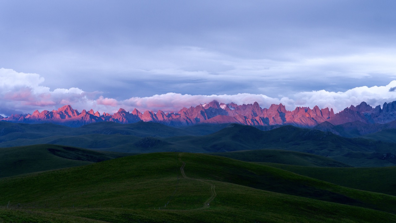 Sunset glow over Nyainbo Yuze ridgelines in Qinghai.