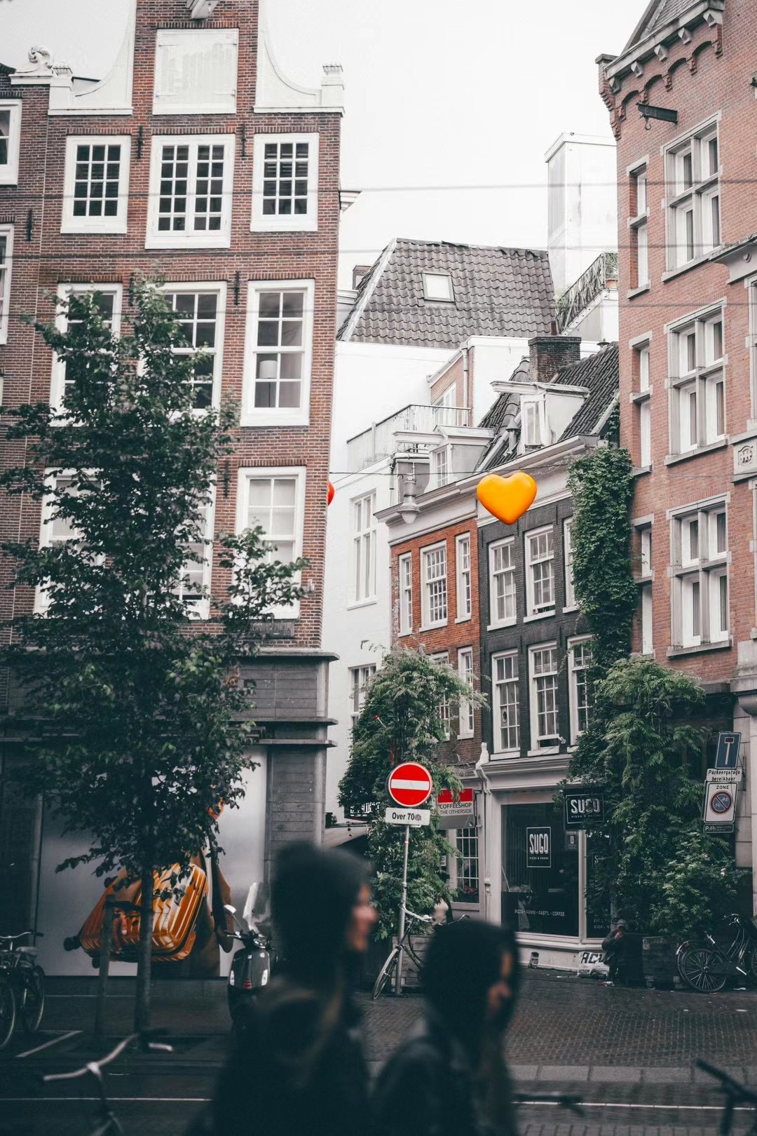 Amsterdam canal houses with playful heart decals and ivy.